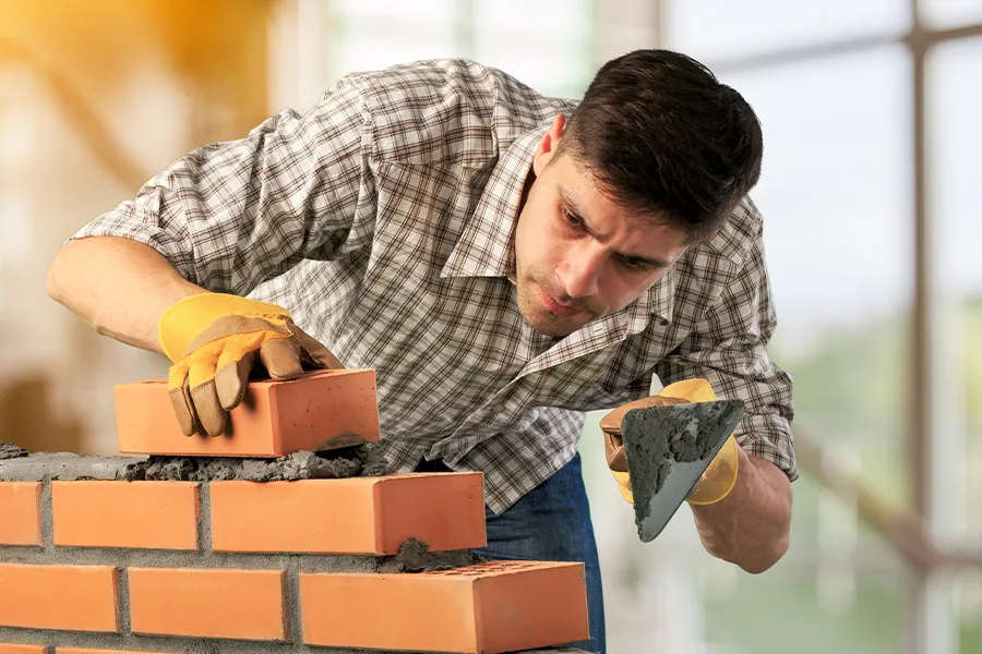 Bild zum Wort „bricklayer“: A person whose job is to build walls, houses and other structures with bricks.