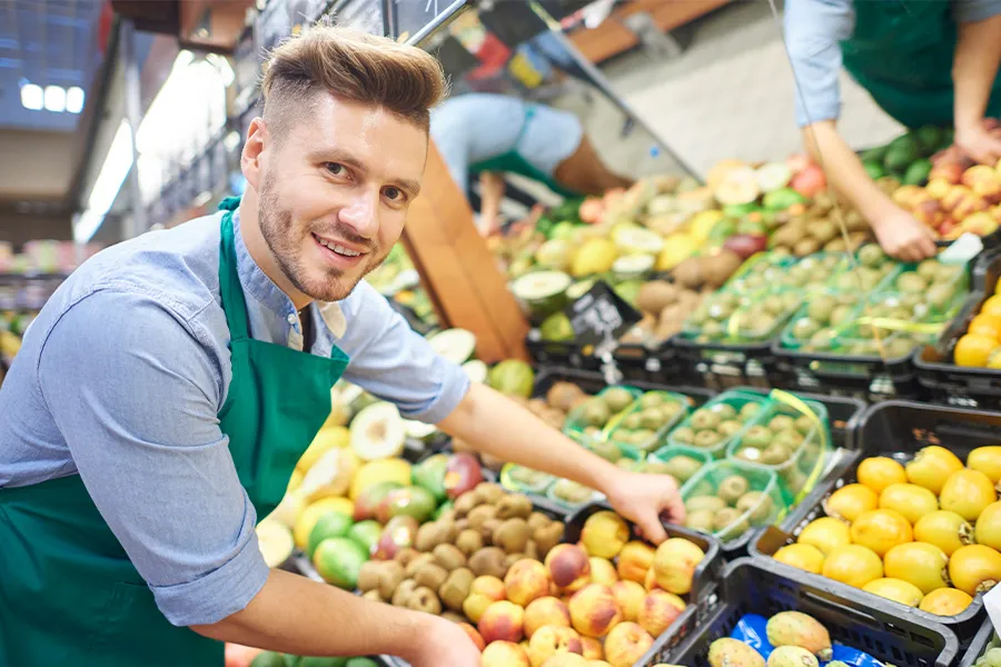 Bild zum Wort „shop worker“: A person who works in a shop, for example serving customers, stacking shelves or working at the till.