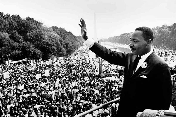 Martin Luther King Jr. winkt einer großen Menschenmenge zu