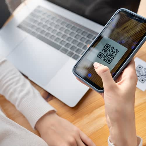 Person scannt mit dem Smartphone einen QR-Code